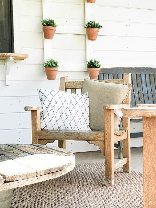 Love the teak chairs, lanterns and wire spool coffee table in this farmhouse summer porch decor!