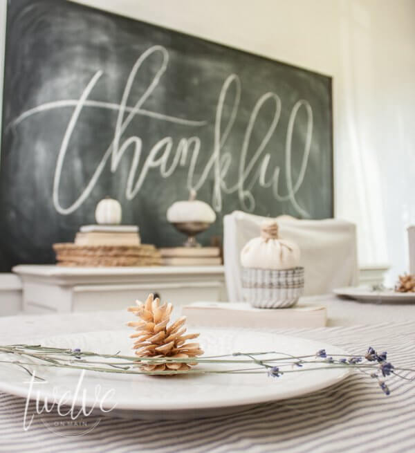 Simple farmhouse fall dining room features....ticking stripe fabric, white pumpkins, old books, and chalkboard art.