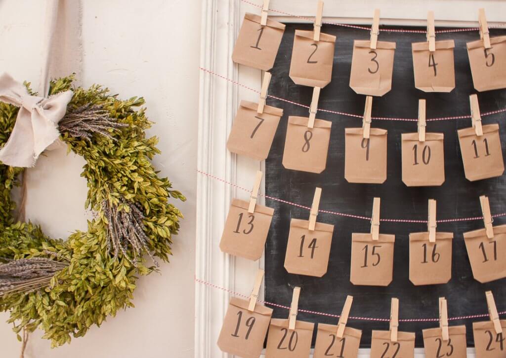 Simple framed chalkboard advent calendar made with simple paper envelopes and clothespins to hang them.
