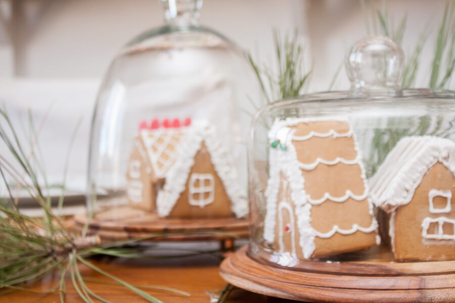 Create a classic red and white farmhouse Christmas tablescape with mini gingerbread houses, red ticking stripe fabric, and nature inspired elements.