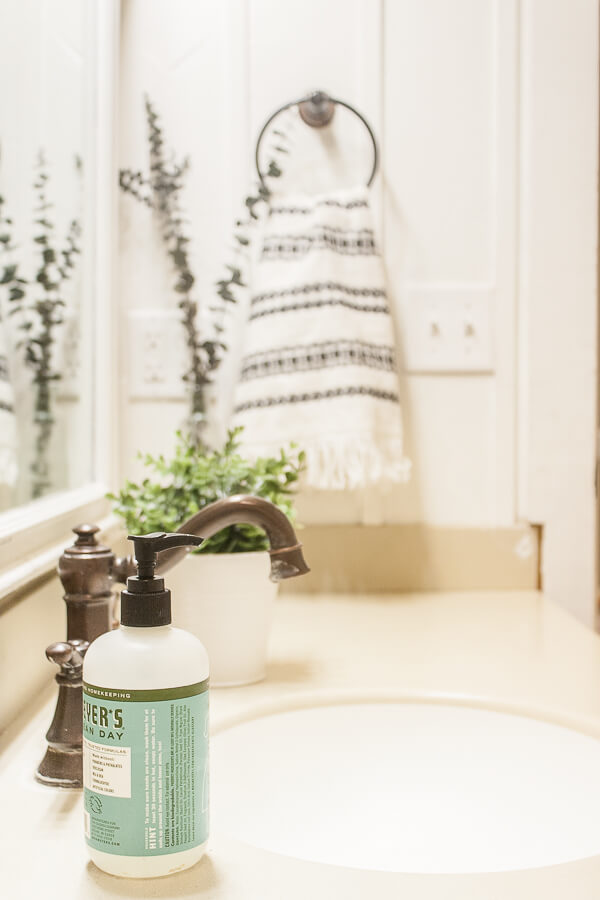 Mrs Meyer hand soap and a tribal inspired hand towel added so much to the bathroom decor in this simple kids bathroom. A little greenery never hurt either!