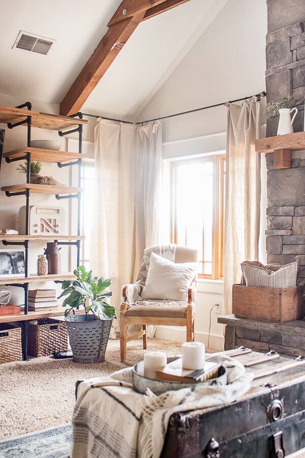 I love the combination of industrial style shelves along with farmhouse accents in this farmhouse living room.
