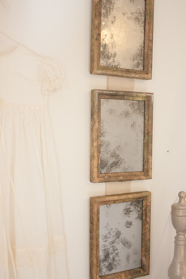Little girls vintage french bedroom with vintage glass light and aged vintage mirrors made from old thrift store picture frames.