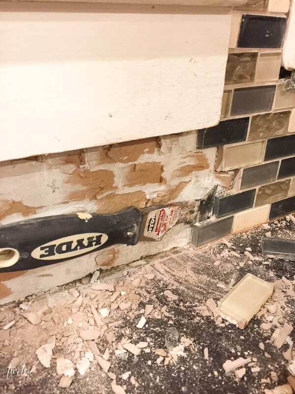 The process of removing tile backsplash with a chisel and a hammer