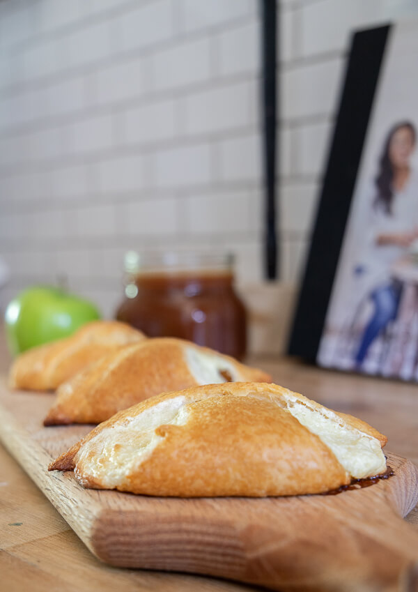Sweet apple dessert with indulgent cream cheese and homemade caramel sauce wrapped in a crescent roll!