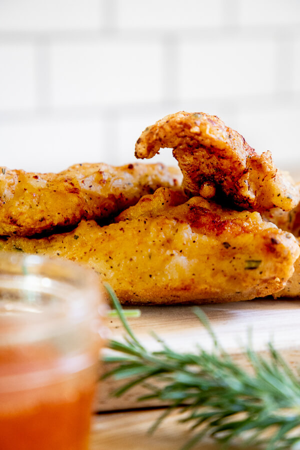 You will never believe what I use to make the crispiest fried chicken ever! Its Argo corn starch! This fried chicken recipe is full of savory herb batter, a touch of spice with Sriracha sauce and a sweet and spicy honey Sriracha dipping sauce that is the perfect compliment to the flavorful fried chicken.