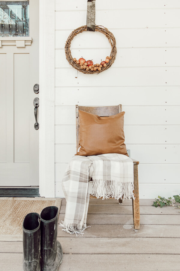 Welcome to my home for fall. My porch is decked out with simple fall items. A black primitive bench, handmade apple and walnut fall wreaths, stacks of firewood, and baskets of leaves. A lone pumpkin rounds out the decor.