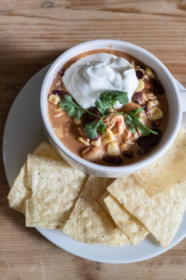 Make this easy crock pot white chicken chili recipe now! Its the perfect meal on a cold fall day. Warm yourself with the spicy flavor and enjoy the creaminess of the chili with the tender chicken that has been cooked all day! Make your dinner easy by making this slow cooker white chicken chili!