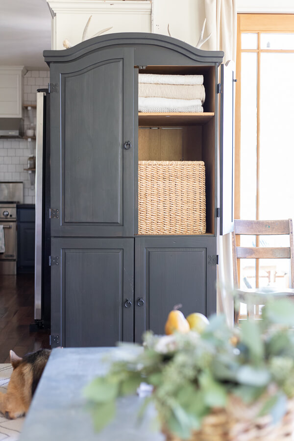 Black armoire in the living room. Stylish and functional, creating storage that is sorely needed. How I took an unloved cheap piece of broken furniture and transformed it. 