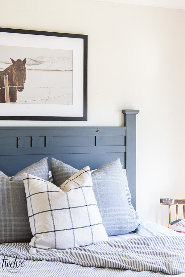 Teenage boys bedroom complete with simple white walls, ticking strip bedding, grey plaid pillows and some horse photography to round it out.