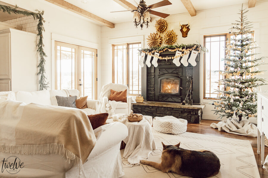 Get some cozy Christmas living room decor inspiration with wood stump coffee tables, cedar garland, a unique advent calendar, white Ektorp sectional, gorgeous painted black fireplace and so much more.