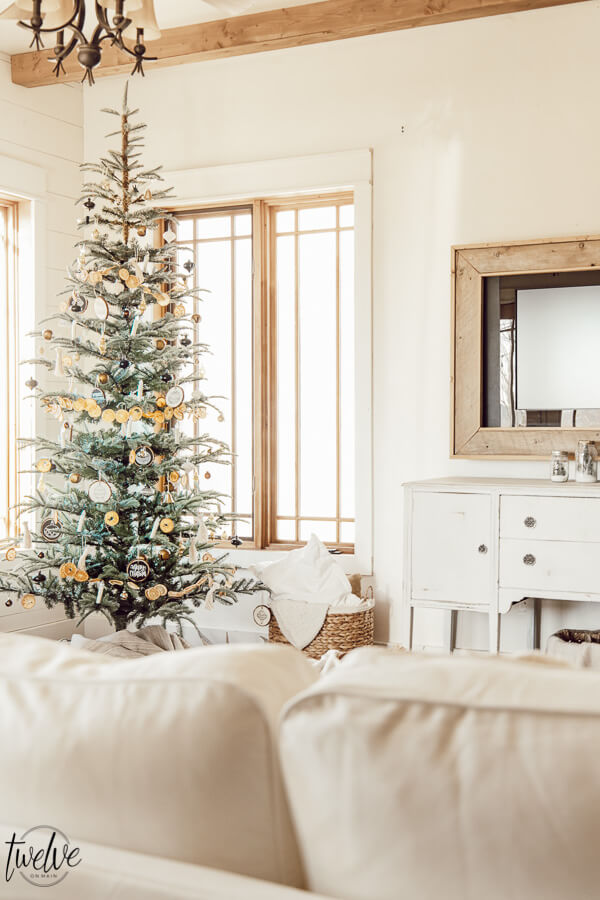 Get some cozy Christmas living room decor inspiration with wood stump coffee tables, cedar garland, a unique advent calendar, white Ektorp sectional, gorgeous painted black fireplace and so much more.