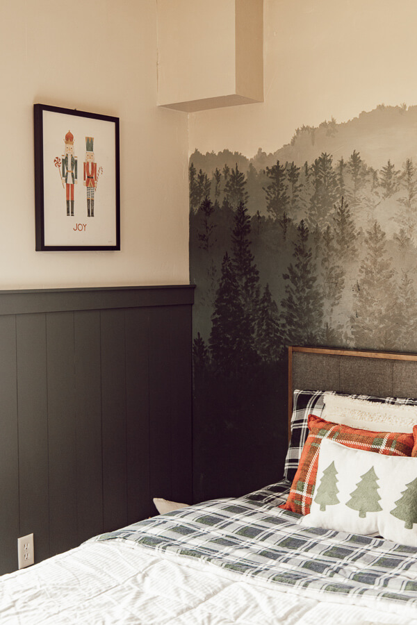 This hand painted forest wall mural along with the plaid flannel sheets and simple Christmas pillows create the most magical kids Christmas bedroom