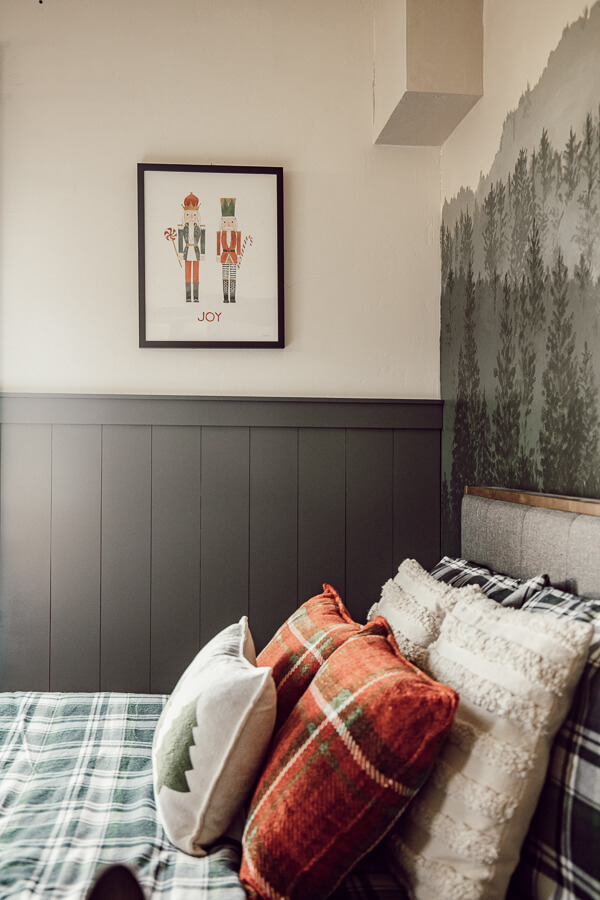 This hand painted forest wall mural along with the plaid flannel sheets and simple Christmas pillows create the most magical kids Christmas bedroom