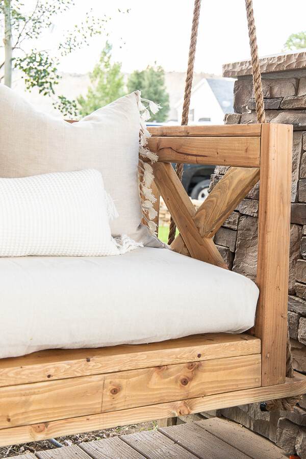 Make this easy DIY porch swing using these easy to follow building plans. This is stylish, and so cozy! Make sure to check it out!