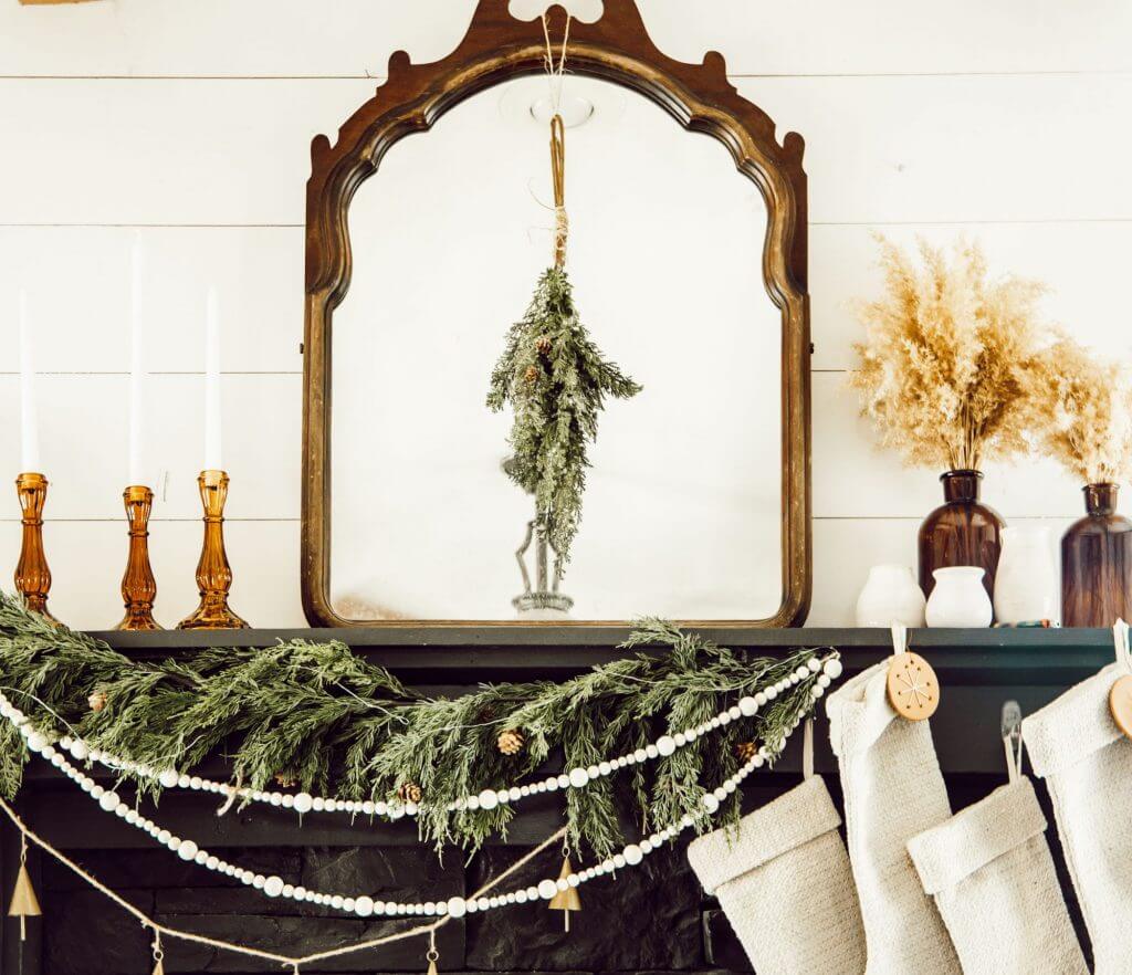 Gorgeous English country Christmas Mantel Decor ideas.  With cedar garland, amber glass accessories, antique mirrors, beaded garland and more.
