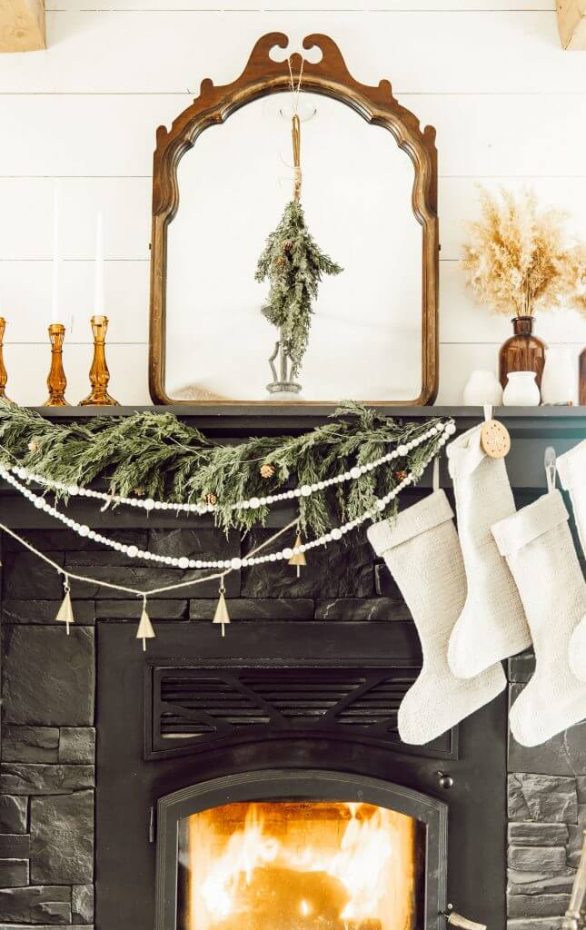 Gorgeous English country Christmas Mantel Decor ideas.  With cedar garland, amber glass accessories, antique mirrors, beaded garland and more.