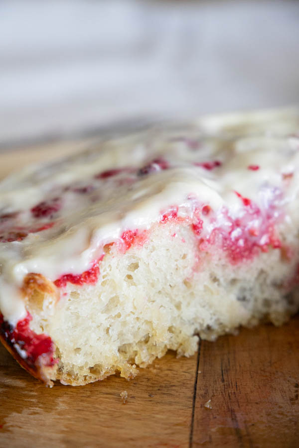 This is the perfectly sweet take on sourdough focaccia bread. This raspberry sourdough focaccia bread is sweet and tangy with juicy raspberries throughout and a decadent cream cheese icing drizzled on top.